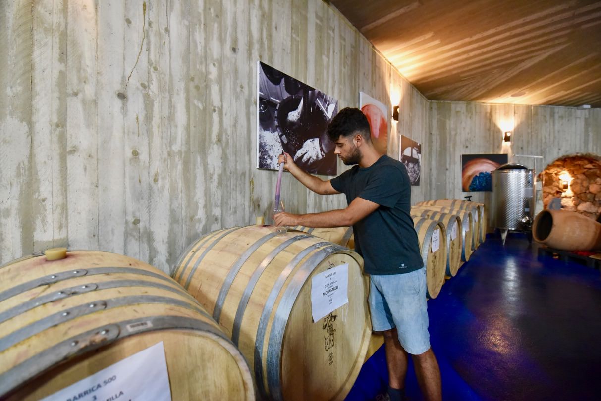 A winemaker working beside a barrel in the Cerrón cellar