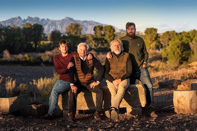 Four members of the Gramona family seated together beside the vineyards