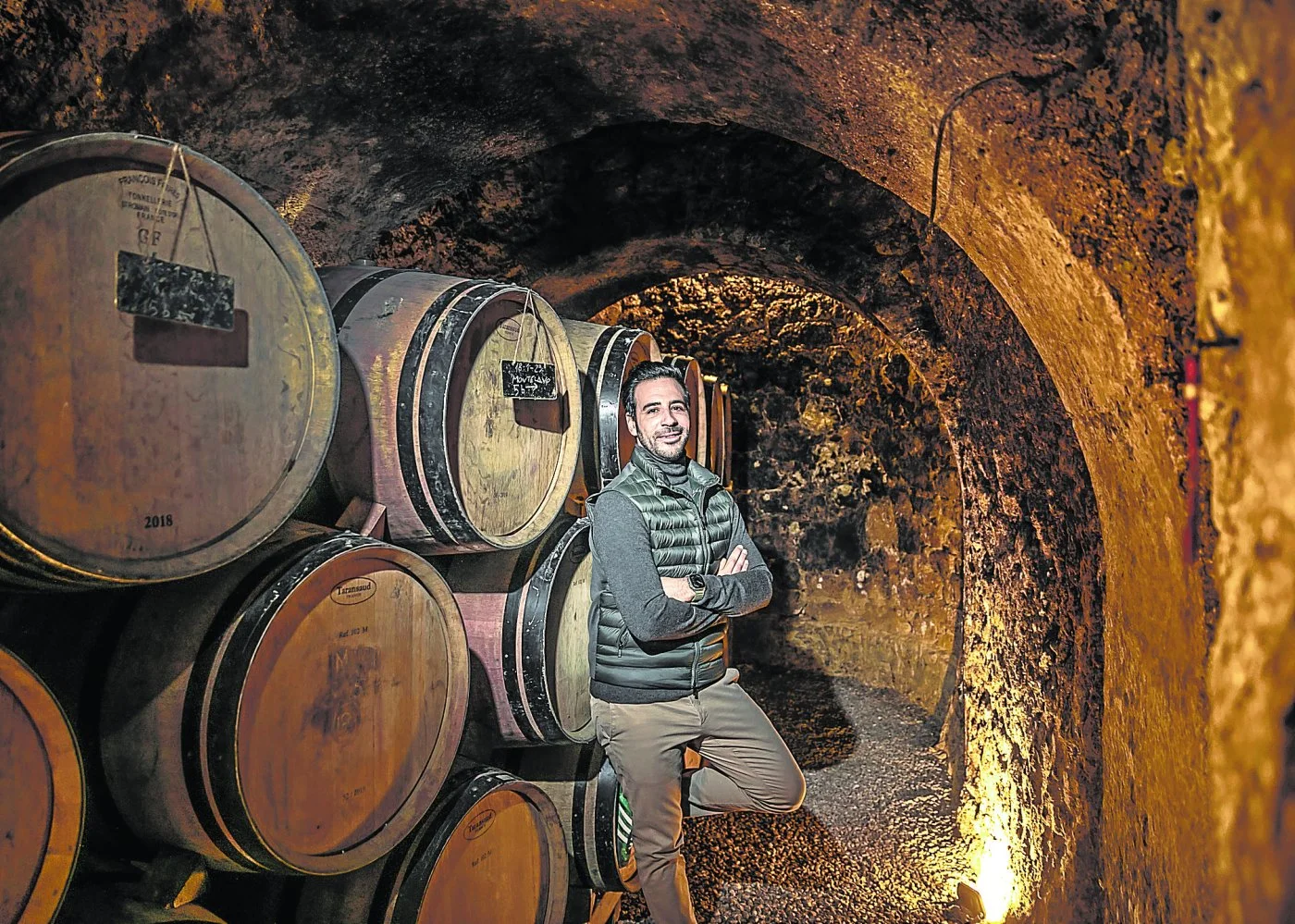 Eduardo Eguren standing beside barrels in the arched Cuentaviñas cellar