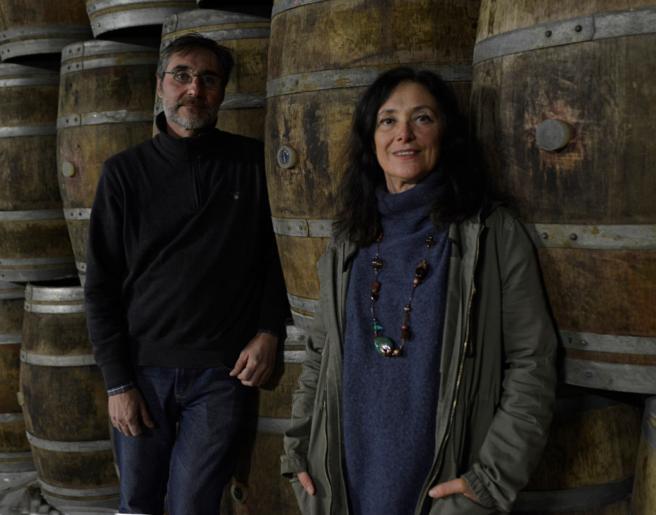 Chiara Boschis and a member of the Boschis family among old barrels