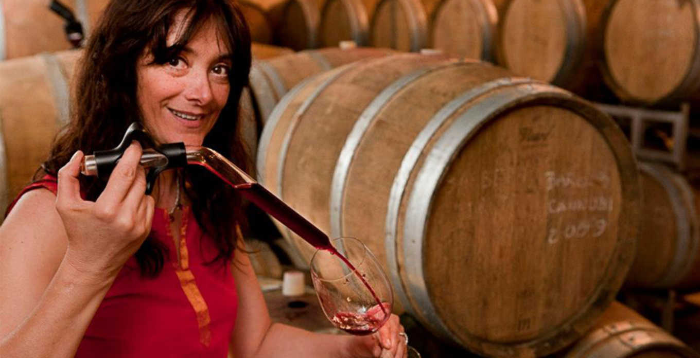 Chiara Boschis drawing red wine from a barrel in the cellar