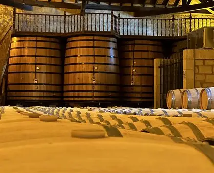 Oak barrels and tall wooden fermentation vats in the Sierra Cantabria cellar