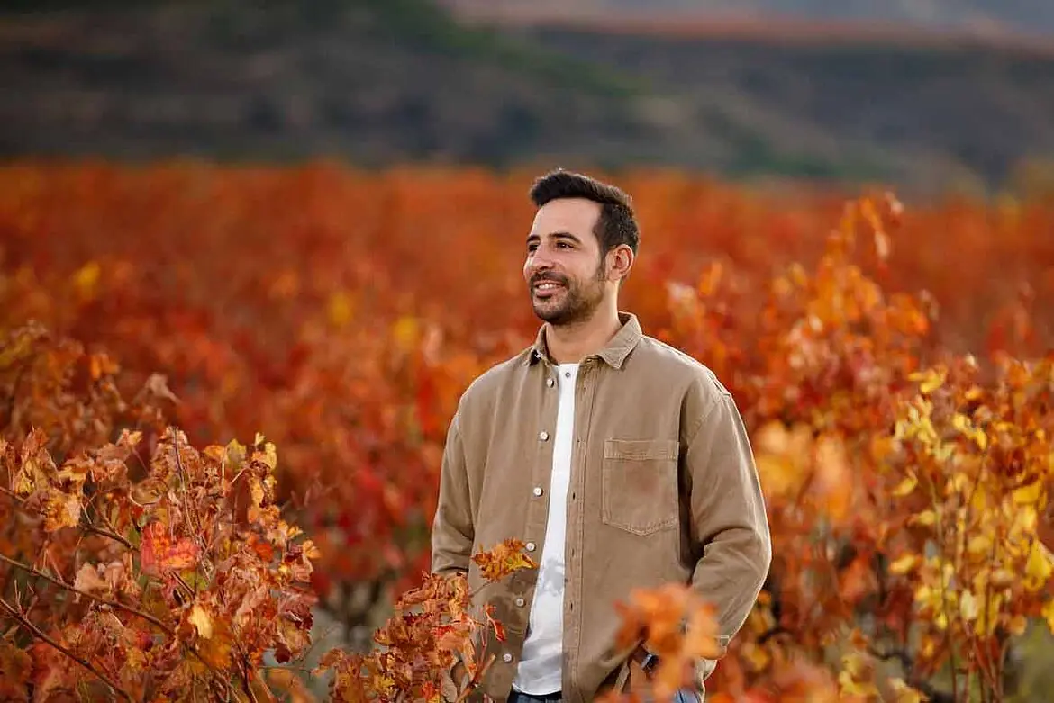 Eduardo Eguren standing among the autumn vines in Rioja