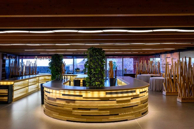 The illuminated oak counter of Ambivium beneath its wooden ceiling
