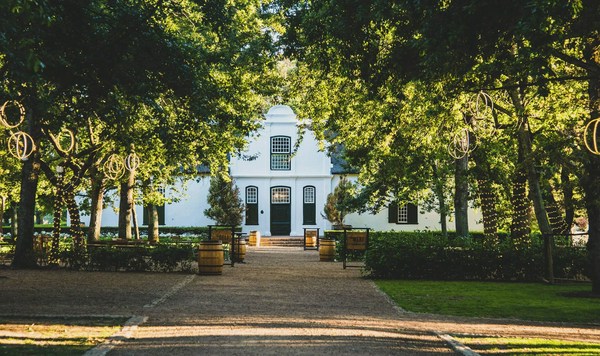 A white Cape Dutch homestead framed by trees