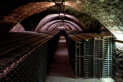 Rows of bottles ageing beneath an old brick arch in the Gramona cellar