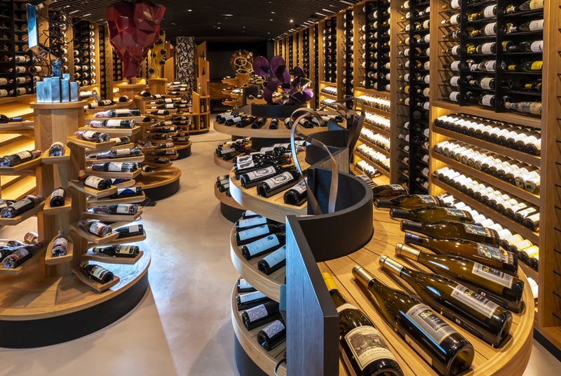Curved oak shelves in the Ambivium cellar holding bottles from the great estates