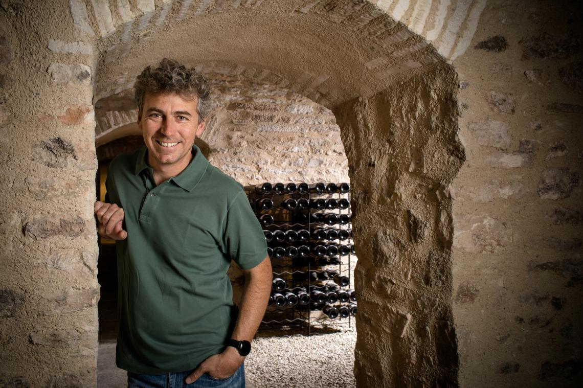 Guillaume Michel standing in the vaulted stone cellar
