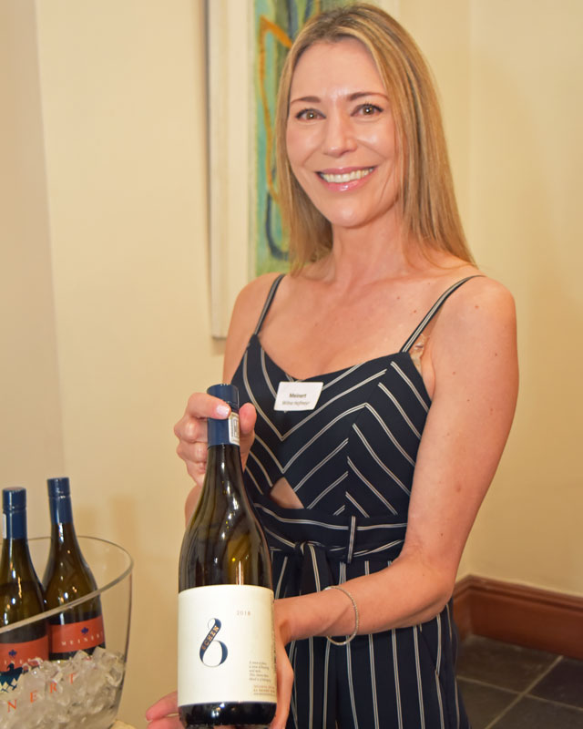 Wilna Hofmeyr presenting a bottle of Meinert wine