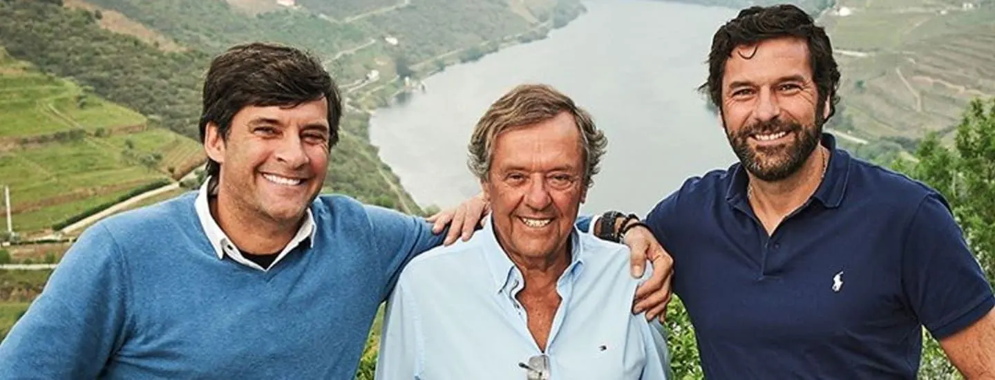 Three men standing above the Douro with terraced vineyards behind