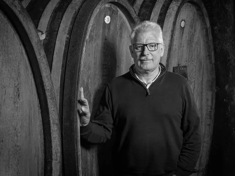 Pierre Trimbach standing beside traditional wooden casks